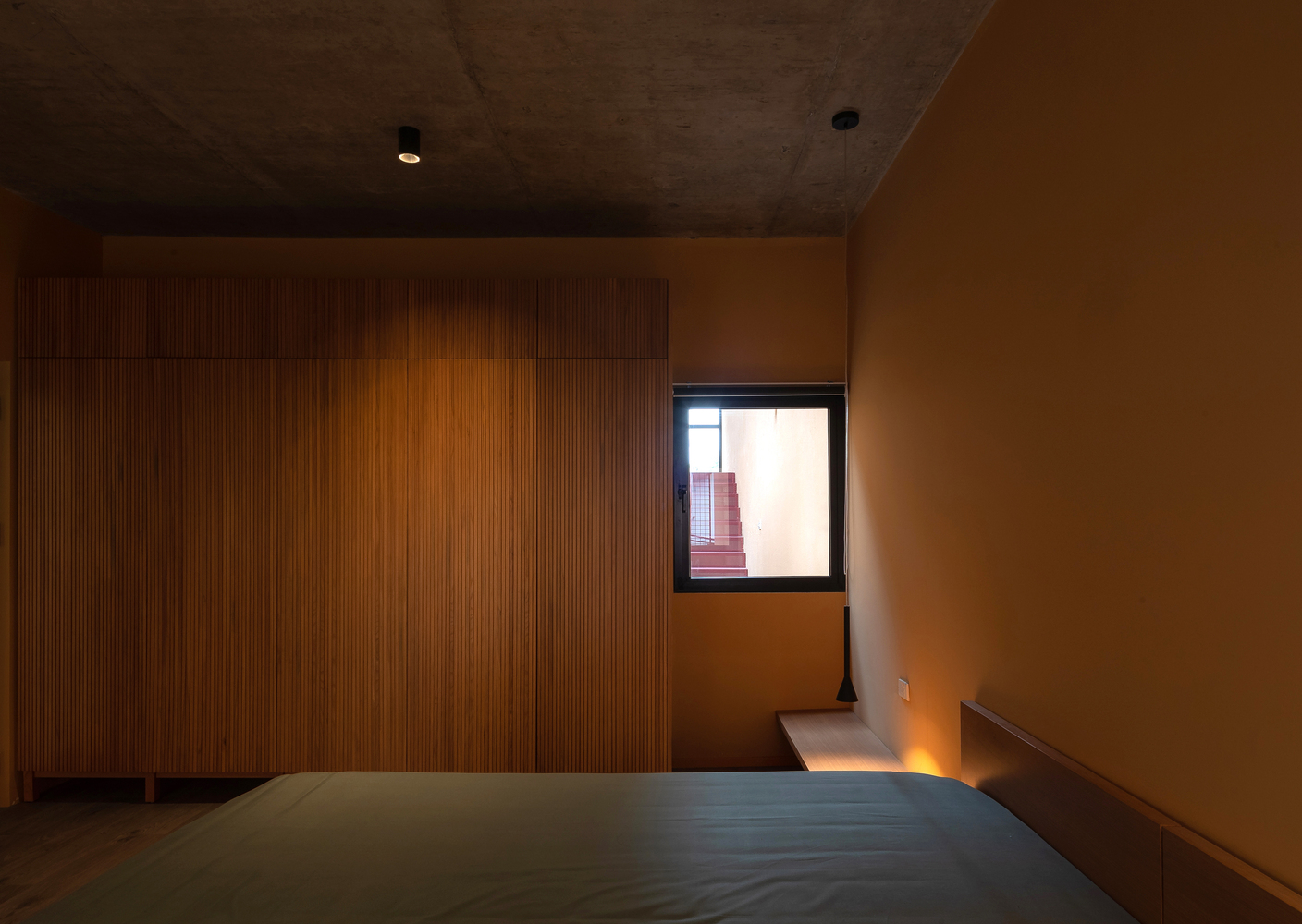 Những ô cửa kính trong suốt xung quanh phòng ngủ đóng vai trò lấy sáng, kết hợp hệ thống đèn âm trần nhỏ gọn tạo sự tươi sáng mà vẫn tạo sự riêng tư cho gia chủ.