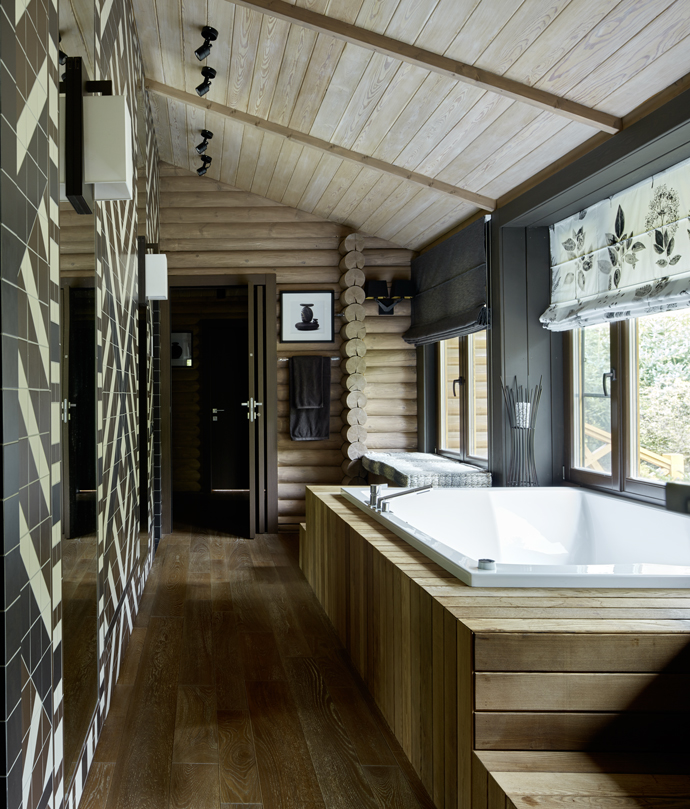 Khác với sự tươi sáng của những phòng tắm trên, căn phòng này nằm trong ngôi nhà gỗ nhìn ra khu rừng mướt xanh lãng mạn. Trần nhà, tường và sàn đều sử dụng gỗ, riêng bồn tắm bằng sứ ốp gỗ xung quanh tạo điểm nhấn trầm mặc, an yên giữa núi rừng.