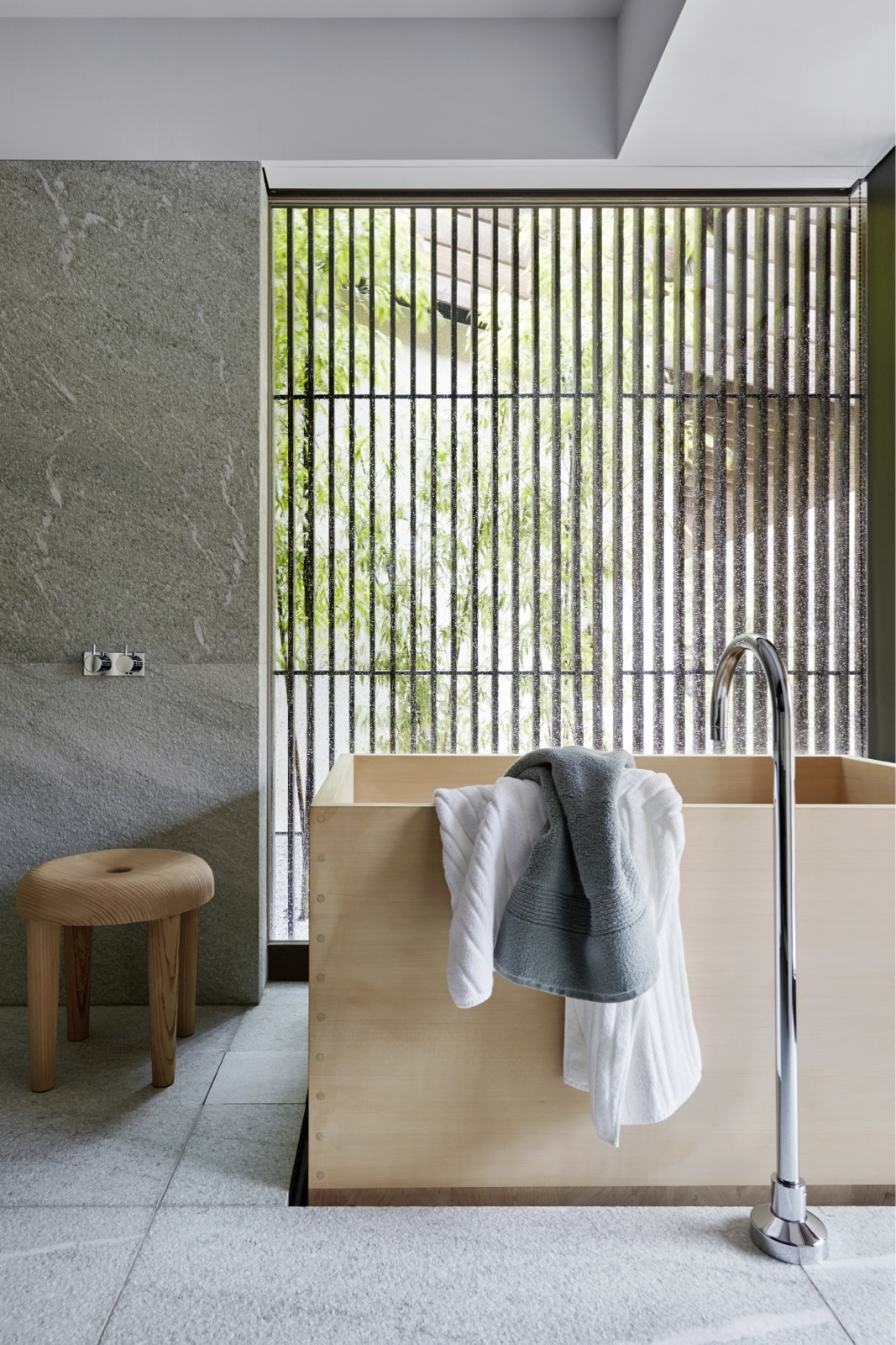Phòng tắm phong cách tối giản được thực hiện bởi KTS Kengo Kuma và studio thiết kế nội thất Liaigre tại Paris. Chiếc bồn tắm và ghế gỗ giản dị, đằng sau là bức tường với những chấn song nhìn ra khung cảnh tươi xanh nhẹ nhàng, lãng mạn.