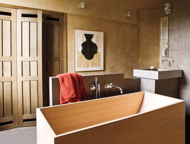 Dự án của nhà thiết kế Christophe Delcourt cho thấy một không gian phòng tắm ngập tràn sự ấm cúng, từ màu sắc cho đến vật liệu. Cửa ra vào, bồn tắm nằm bằng gỗ tự nhiên gia công sắc sảo. Cả loại đá ốp tường và tranh trang trí cũng chọn gam màu nâu mộc mạc cho vẻ đẹp ấm áp tuyệt đối.