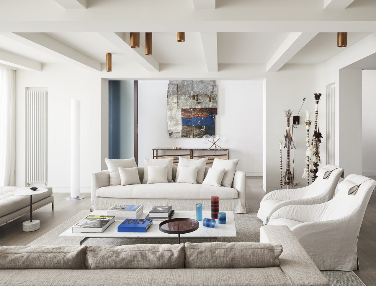 Một không gian tiếp khách phụ được bày trí không thua kém gì nội thất của phòng khách chính, với những bộ ghế sofa và ghế bành êm ái, sắc màu trắng - xám nhẹ nhàng, xếp đặt trên một tấm thảm cỡ lớn. 