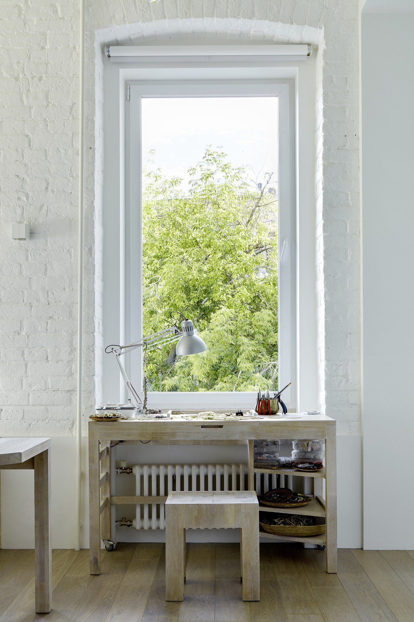 Góc làm việc nhỏ nhưng vô cùng xinh xắn này được thực hiện bởi NTK Svetlana Nesterushkina. Nội thất đơn giản với bộ bàn ghế gỗ sáng màu, bên ngoài khung cửa là vẻ đẹp của những tán cây xanh rì rào trong gió, đẹp hơn bất cứ bức tranh vẽ nào.