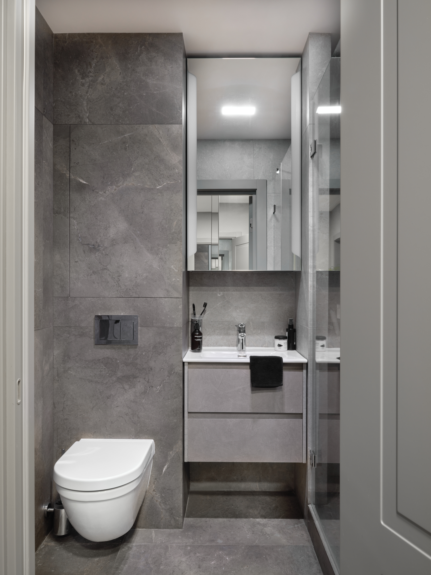 Bồn toilet và tủ vanity gắn tường cũng giúp giải phóng diện tích sàn. Nội thất phòng tắm được lựa chọn là loại vật liệu đá và sứ thế hệ mới của Đức.