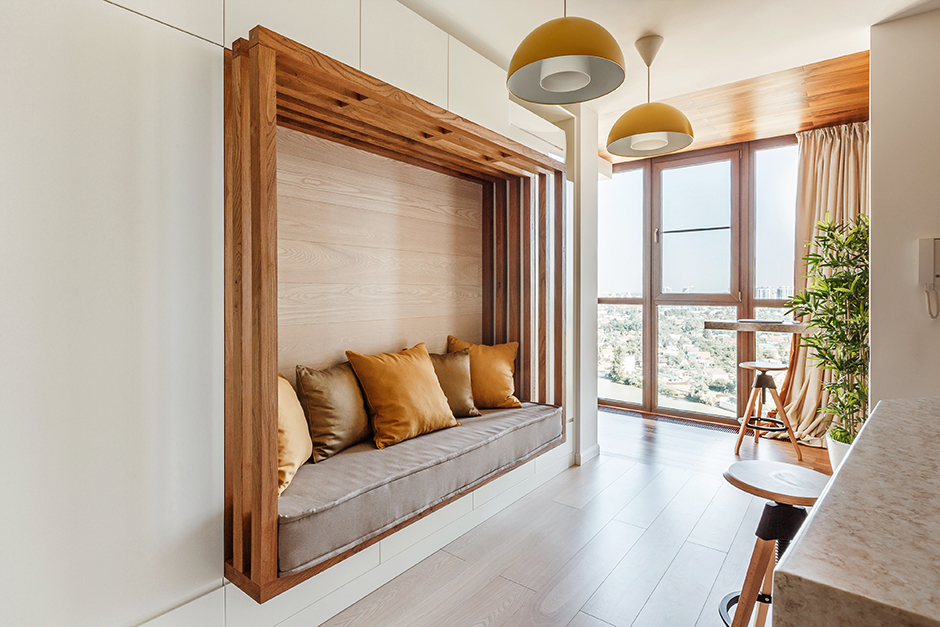 Bằng cách tận dụng hốc tường lớn, NTK nội thất đã sáng tạo nên một phòng khách khó có thể đụng hàng với bất kỳ đâu. Khu vực tiếp khách được 'đóng khung' bởi những thanh lam gỗ vững chãi, hài hòa với nội thất và màu sắc ấm áp xung quanh.
