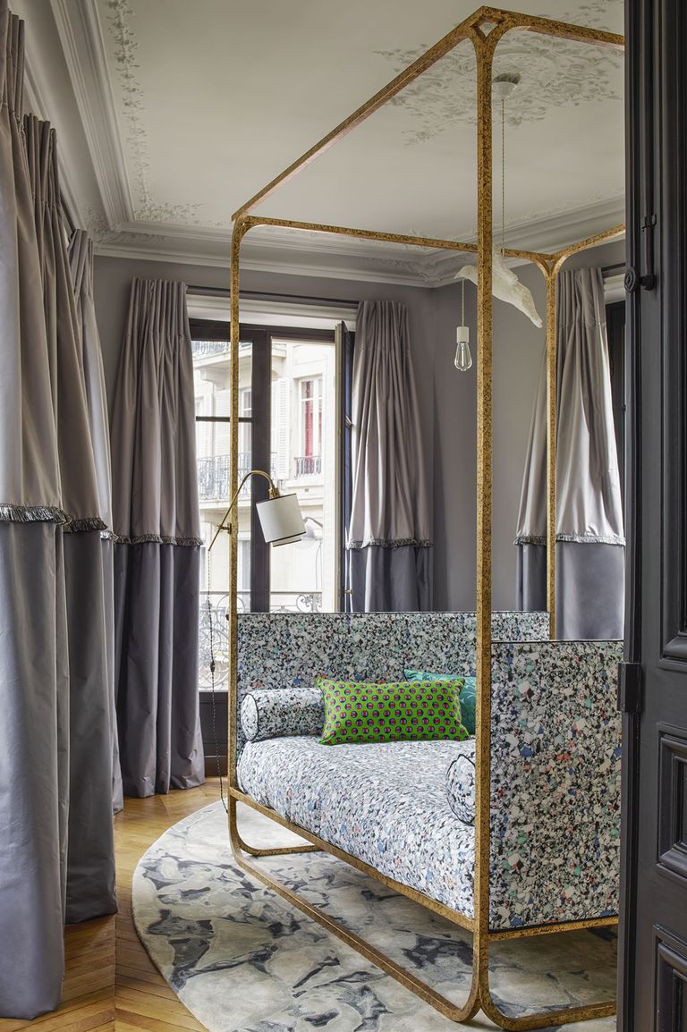 Phòng ngủ trong căn hộ tại Paris (Pháp) được thiết kế dành riêng cho khách đến thăm nhà nghỉ lại. Chiếc giường được đặt thiết kế và gia công theo yêu cầu, ngăn cách với không gian bên ngoài bằng rèm vải dày dặn.