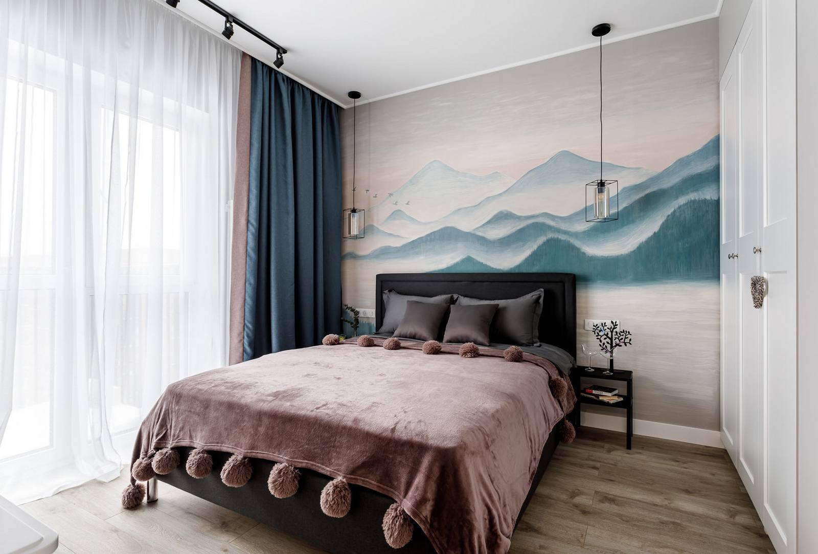 Phòng ngủ gây ấn tượng nhất với bức tranh tường được vẽ tay hoàn toàn với chủ đề phong cảnh sơn thủy hữu tình. Hệ thống rèm che cửa sổ tương tự phòng khách, giường ở vị trí trung tâm với khung màu đen vững chãi cùng tấm chăn mịn mượt.