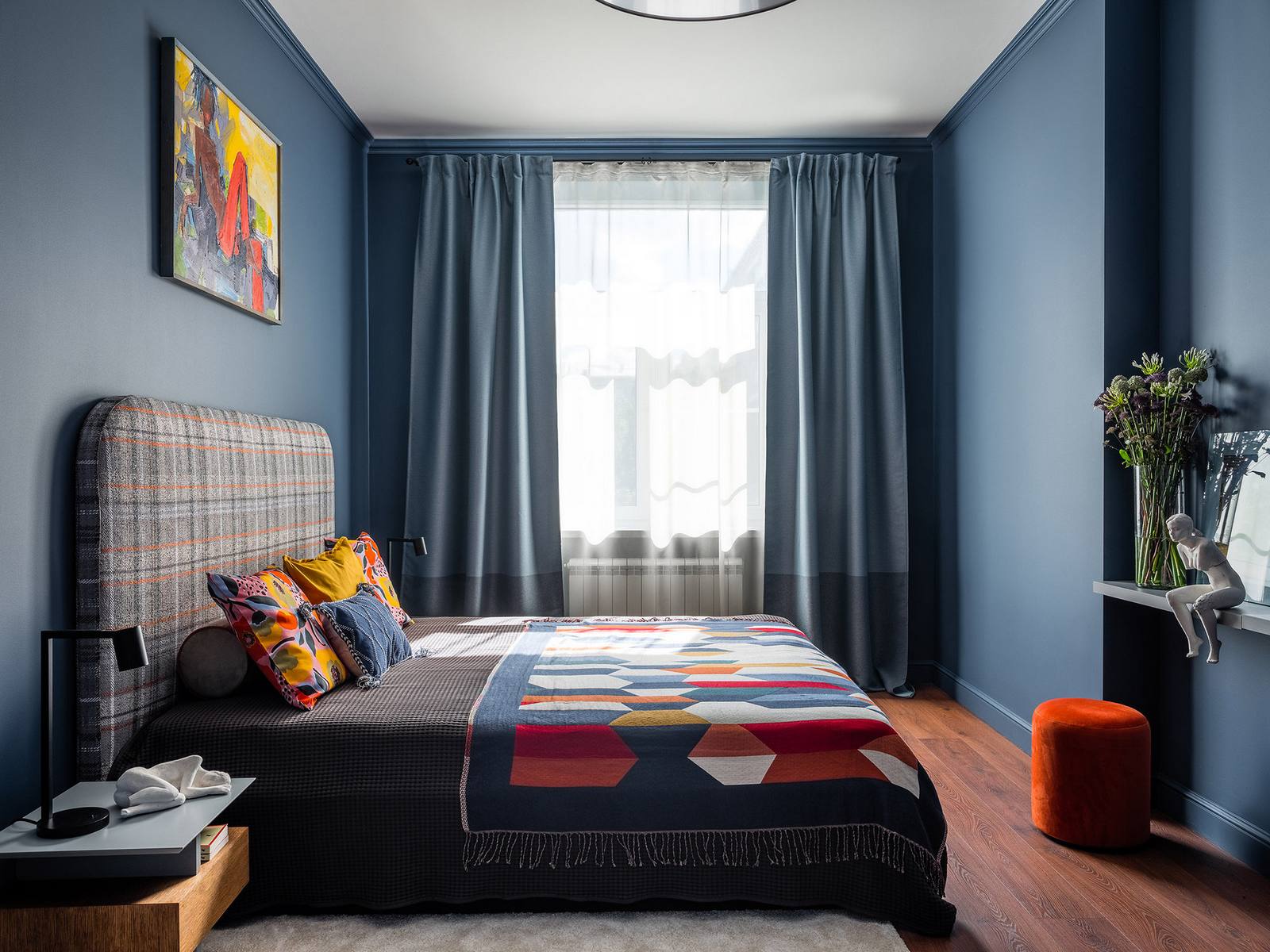 Nếu hành lang, phòng khách sử dụng gam màu xám chủ đạo, phòng bếp lấy nền tường màu cam làm điểm nhấn thì tại phòng ngủ, gam màu xanh lam được ưu ái từ màu sơn cho đến rèm che cửa sổ dày dặn. 