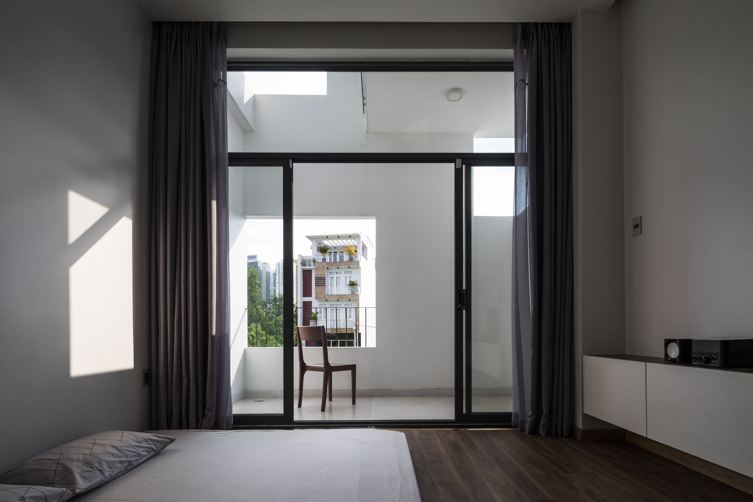 Các phòng ngủ được thiết kế tối giản với cửa kính trượt trong suốt nhìn ra khung cảnh bên ngoài. Rèm che dày dặn cũng được tích hợp để cách âm và tạo sự riêng tư cho gia chủ khi cần.
