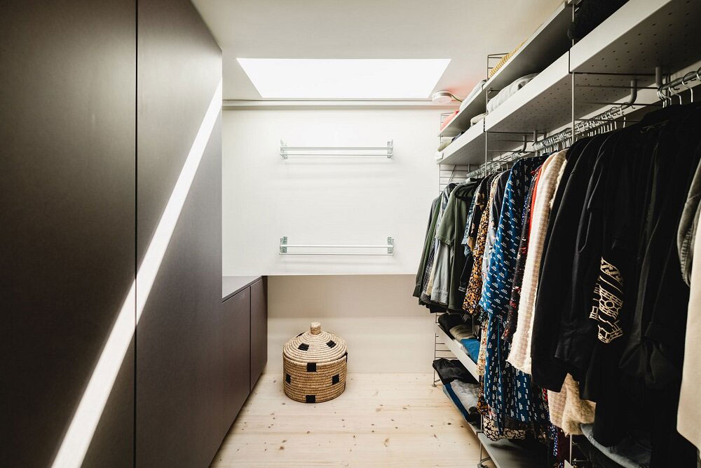 Phòng thay đồ với cửa sổ trần thoáng sáng cùng dãy tủ kệ lưu trữ cho phép chủ nhân sắp xếp các loại trang phục một cách gọn gàng, ngăn nắp.
