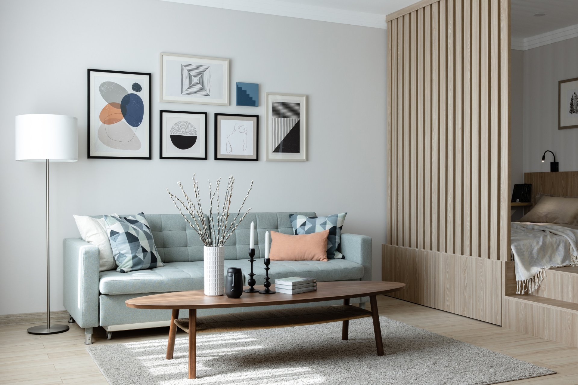 Phòng khách thiết kế đúng chuẩn phong cách Scandinavian thanh lịch với nội thất thiết kế đơn giản, gọn gàng nhưng tinh tế. Chiếc ghế sofa màu xanh bạc hà kết hợp với bàn nước bằng gỗ hình bầu dục nổi bật trên thảm trải sàn mịn mượt.