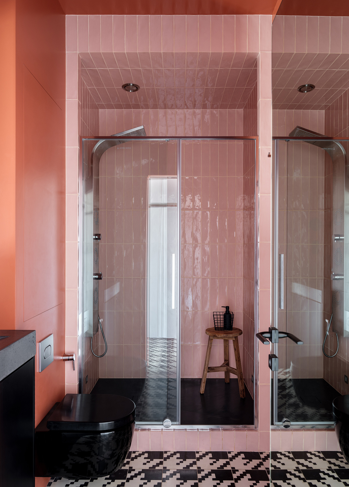 Phòng tắm ấn tượng với sàn nhà lát gạch tương tự hành lang lối vào. Những viên gạch màu hồng ốp dọc tường tạo cảm giác trần nhà cao hơn thực tế. Ngoài ra, độ bóng của gạch kết hợp cửa kính và bức tường gương cho không gian nhỏ rộng thoáng hơn.
