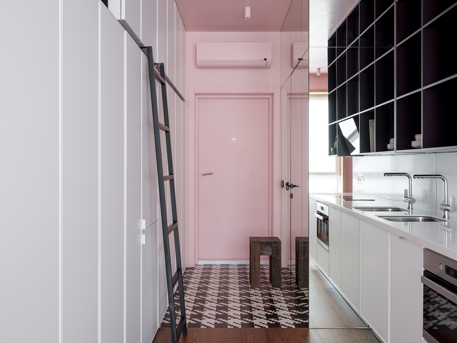 Lối vào căn hộ với tường, trần và cánh cửa màu hồng phấn, ngay cả chiếc máy lạnh và đèn trần cũng được sơn theo gam màu yêu thích của nữ chủ nhân. Phần sàn được lát gạch họa tiết cá tính, nổi bật so với sàn gỗ bên trong khu vực sinh hoạt chính.
