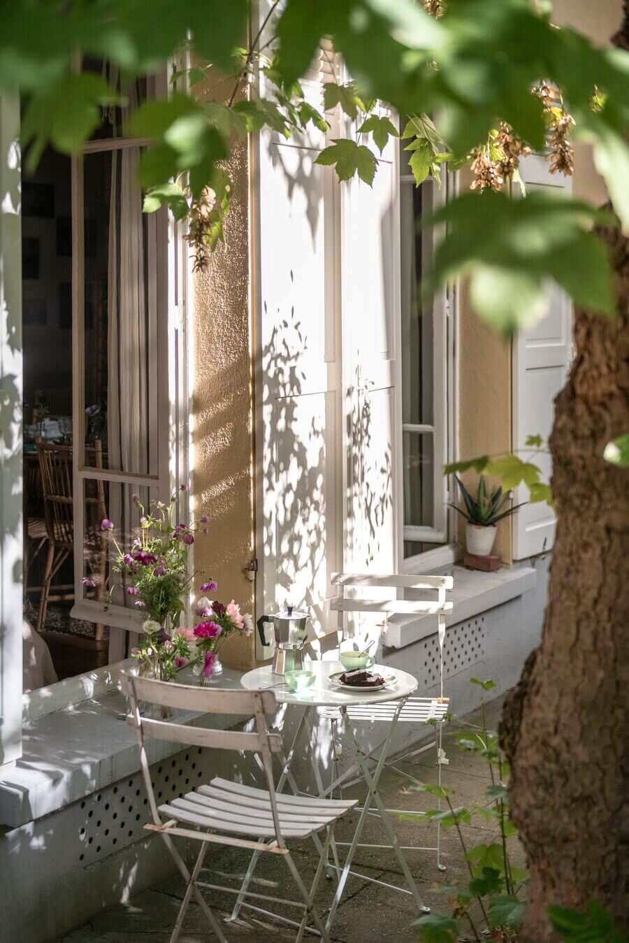 Hình ảnh góc vườn nhỏ bên ngoài căn hộ ở tầng trệt với cây cối tươi xanh, những tia nắng len mình qua tán lá in bóng trên những bức tường,... Thêm vào một bộ bàn ghế ngoài trời, tách trà, cafe, bánh ngọt, làm nên góc thư giãn thật 'chill', thể hiện rõ nét phong cách Paris lãng mạn.
