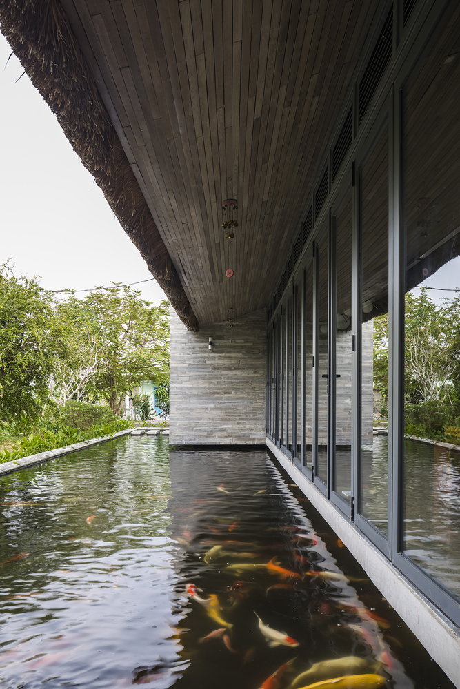Hồ nước lớn được thiết kế nằm sát mặt sàn với khoảng thông tầng chạy dọc hai bên của ngôi nhà với những đàn cá tung tăng bơi lội.