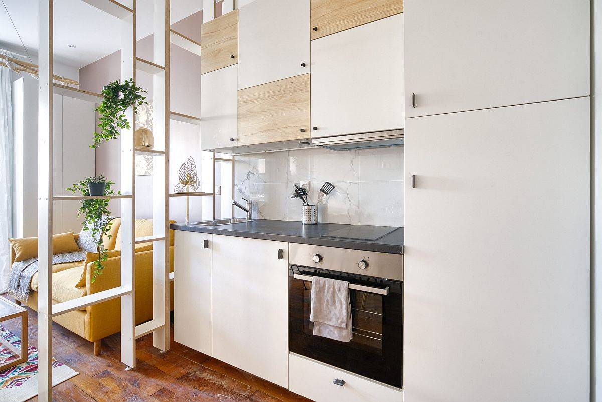 Ngay cả trong không gian phòng bếp và phòng ăn nhỏ thì hệ thống tủ ốp tường cao kịch trần, kệ mở cũng được tận dụng tối đa để tăng cường không gian lưu trữ theo chiều dọc. 
