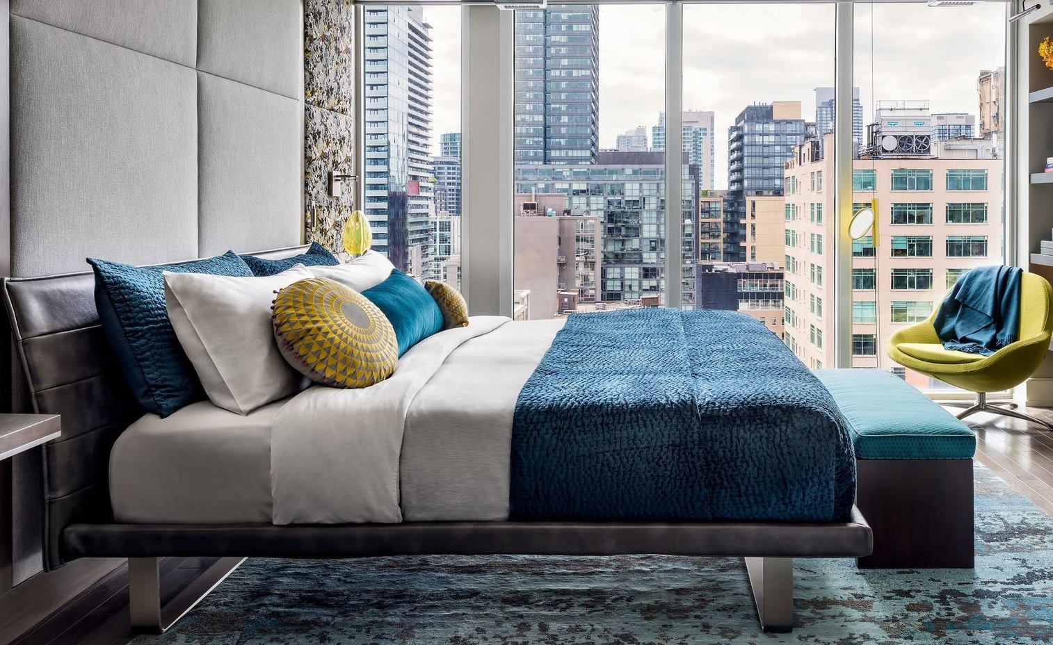 Phòng ngủ với thiết kế tường kính trong suốt nhìn ra khung cảnh nhộn nhịp của Toronto (Canada). Sheree Stuart Design Studio đã kết hợp kiểu giường thấp sàn với khung thép bọc da cực kỳ sang chảnh, phù hợp với phong cách hiện đại tổng thể.