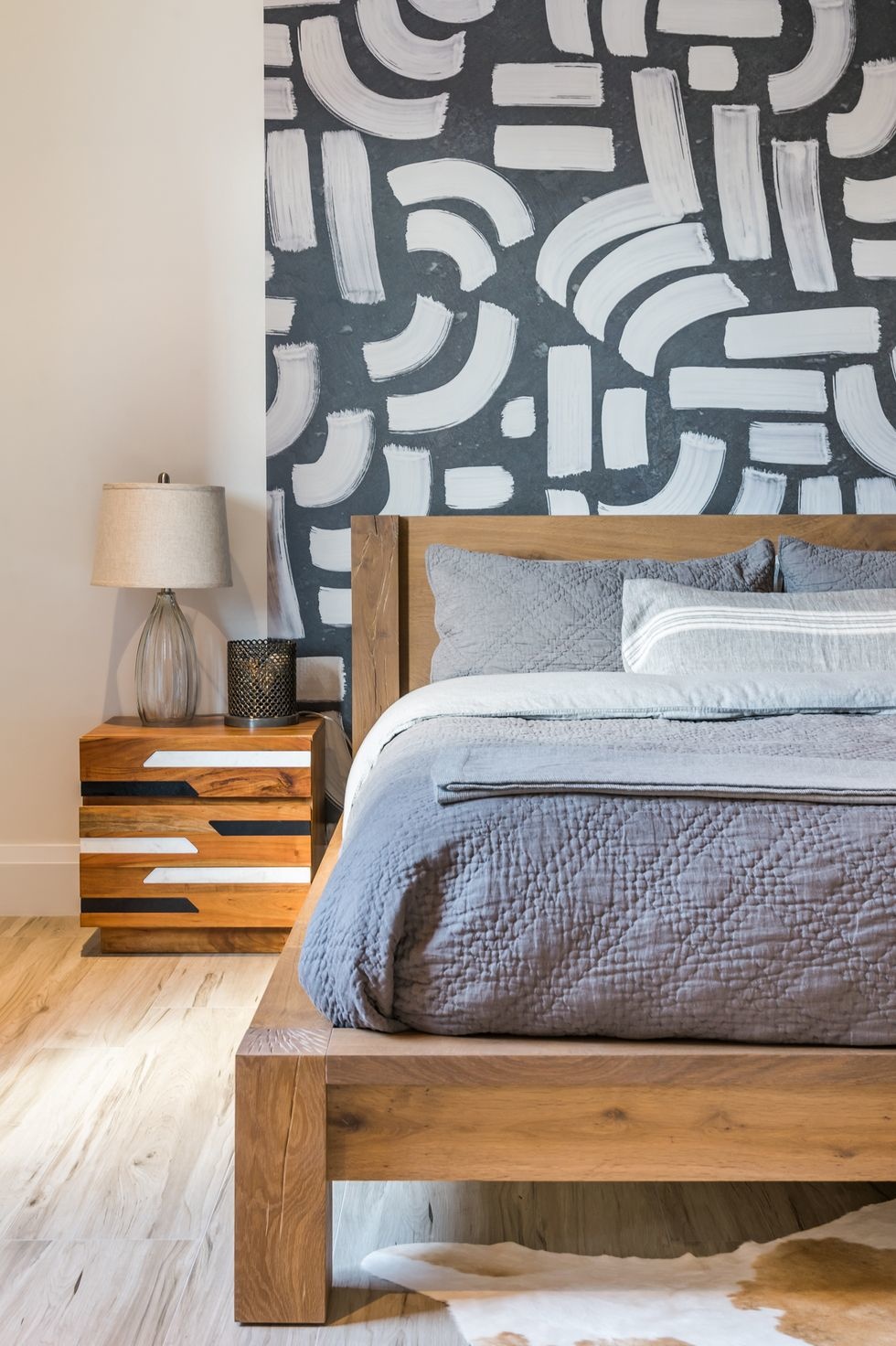 Phòng ngủ mộc mạc do Maritza Capiro Designs thiết kế. Bên cạnh giường gỗ thấp sàn tạo cảm giác căn phòng 'cao' hơn thực tế thì chiếc táp đầu giường và giấy dán họa tiết độc đáo cũng góp phần tạo nên sự lôi cuốn cho không gian thư giãn.