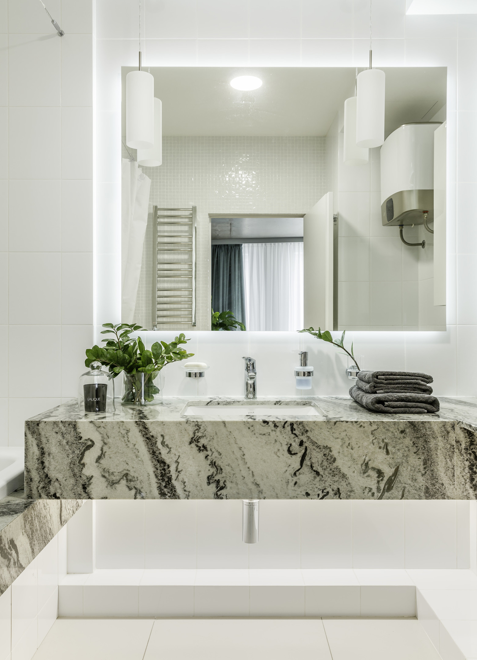Dự án tại Moscow (Nga) do Room Design Buro thực hiện với ý tưởng sử dụng vật liệu đá cẩm thạch để thiết kế bồn rửa tay đẹp mắt, biến nó thành nét chấm phá tự nhiên, nổi bật giữa phông nền toàn sắc trắng đơn điệu trong phòng tắm.