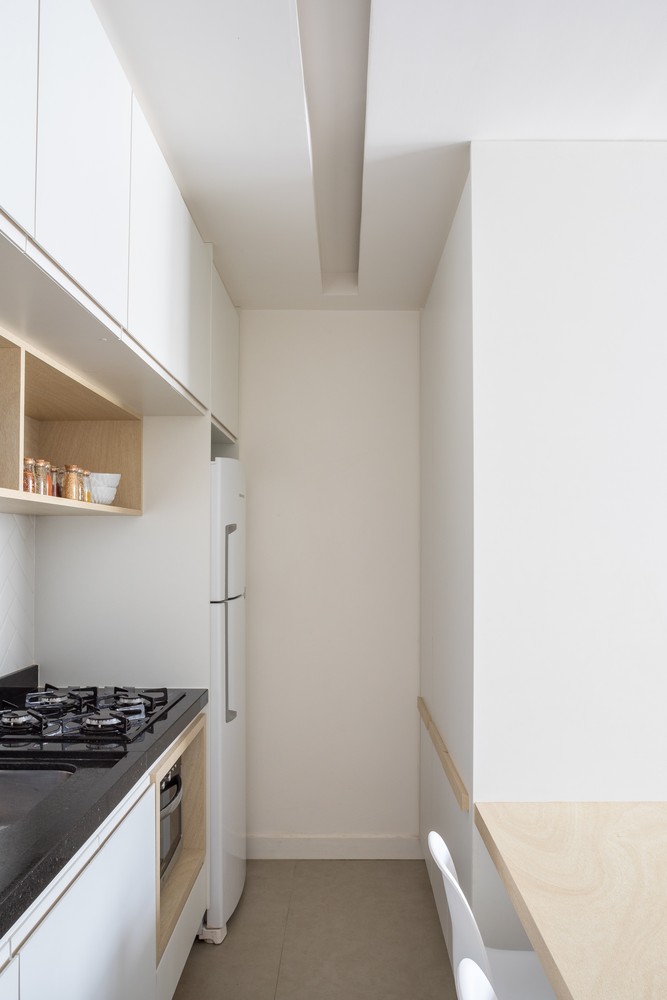 Phòng bếp lựa chọn hệ tủ bếp thiết kế kiểu chữ I - nội thất bố trí trên một đường thẳng duy nhất - là giải pháp hoàn hảo cho những căn hộ nhỏ, ít thành viên. Chiếc tủ lạnh màu trắng được bố trí trong góc tường, “ẩn nấp” một cách gọn gàng.
