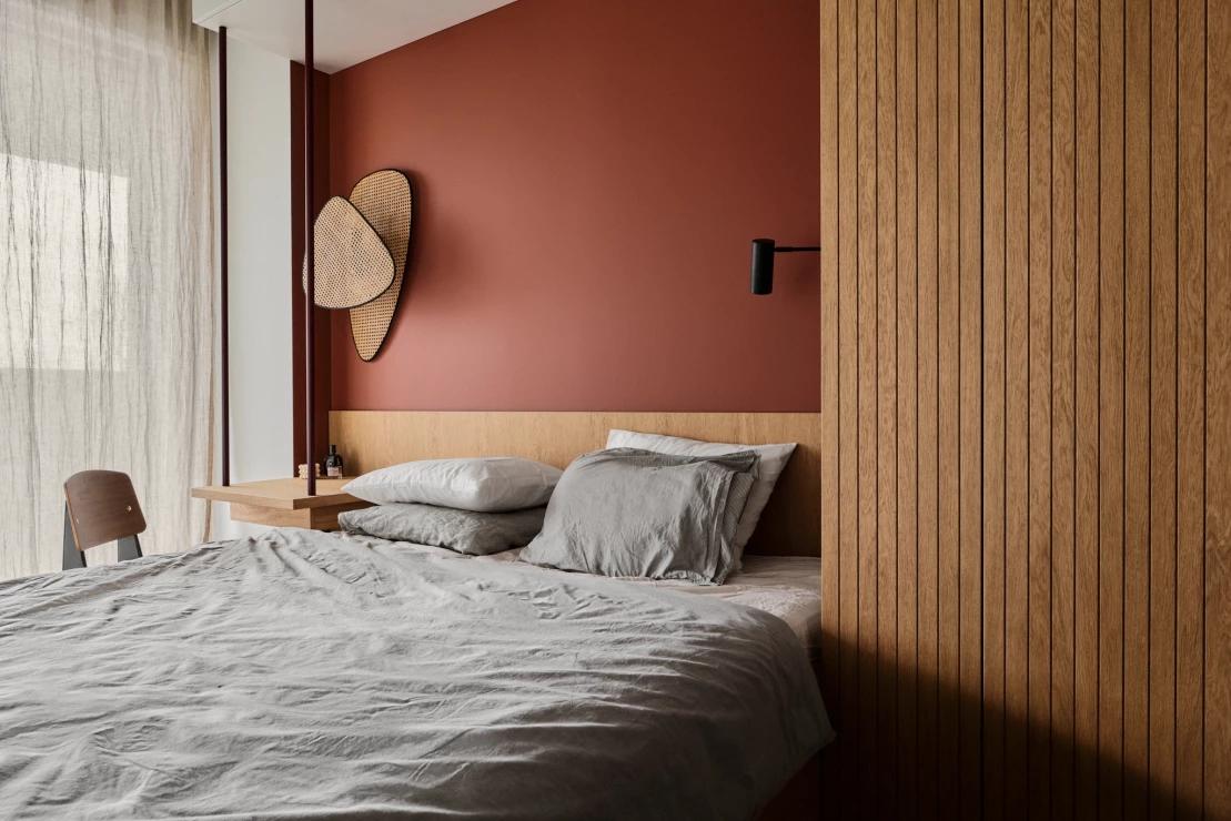 Màu đất nung là gam màu phổ biến để kết hợp với những các sắc thái của vật liệu nội thất, từ gỗ, kim loại cho đến vải dệt,... Phòng ngủ do Odwzorowanie Studio thiết kế đã kết hợp sơn tường màu đất nung với vật liệu gỗ cho cảm giác ấm áp tuyệt đối.