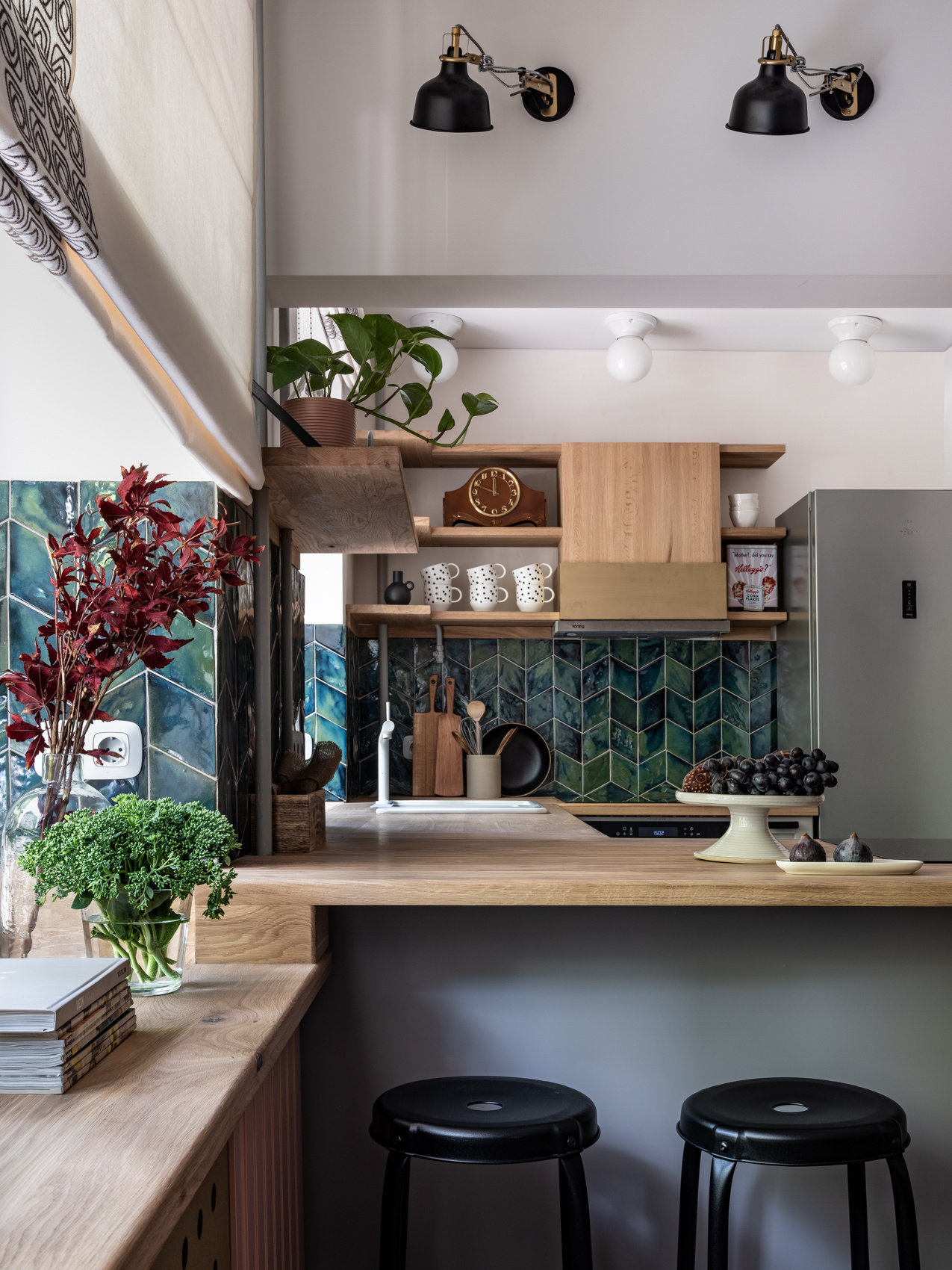 Dự án của nhà thiết kế nội thất Malika Boranbaeva, biến khu vực backsplash nhỏ trở thành từng đợt sóng biển màu xanh đẹp mắt. Bên trên là hệ thống kệ lưu trữ giúp tối ưu hóa bức tường trong phòng bếp nhỏ.