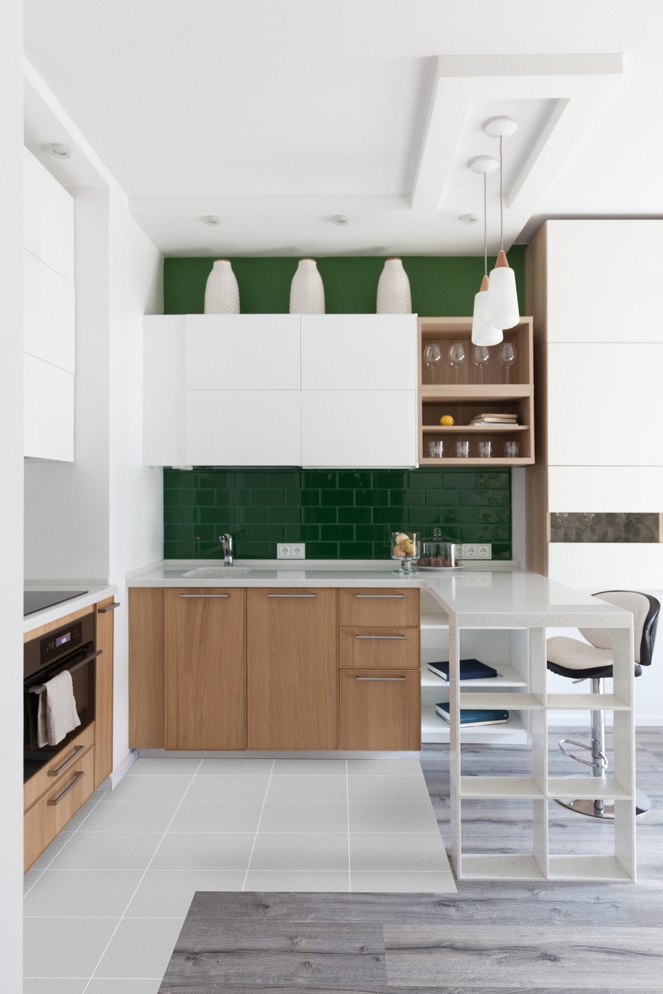 Dự án của nhà thiết kế Yulia Belyaeva với gam màu trắng kết hợp nội thất gỗ ấm áp cho không gian nhỏ rộng rãi hơn. Bên cạnh đó, những viên gạch thẻ metro màu xanh ngọc lục bảo giúp cho phòng bếp tối giản bớt đi sự nhàm chán, trái lại rất tươi mới.