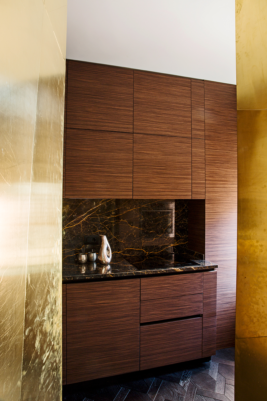 KTS Massimo Adario đã thiết kế phòng bếp trong căn hộ với kiểu tủ chữ I kích thước cao kịch trần nhằm tối ưu hóa không gian. Riêng backsplash được ốp đá cẩm thạch đường vân màu đen và cánh gián siêu sang chảnh.