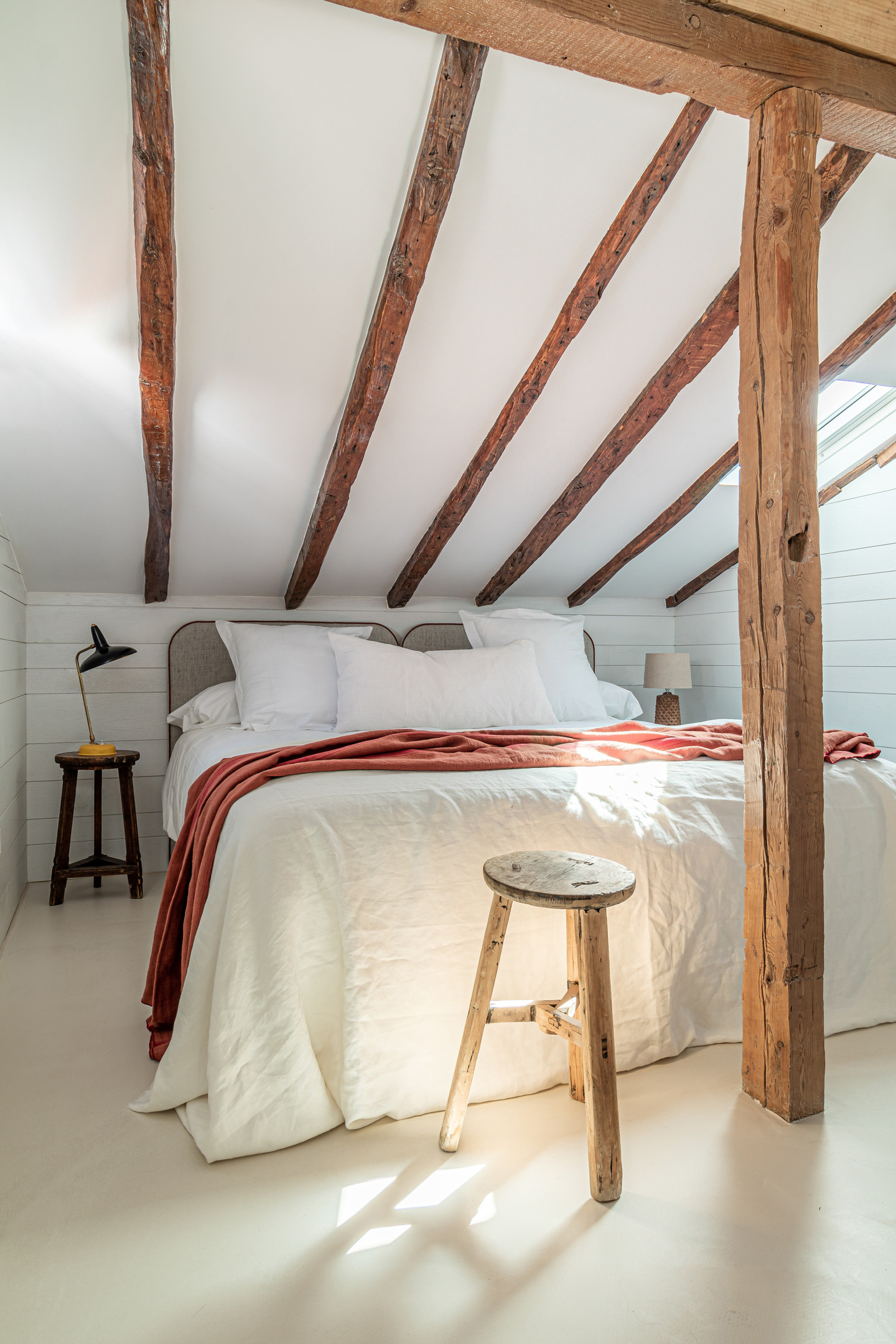 Tầng trên bao gồm 2 phòng ngủ và 1 phòng tắm riêng biệt. Tường, sàn và trần xi măng sơn màu trắng cho cảm giác căn hộ được 'nâng cao' lên về mặt thị giác. Dầm gỗ trên trần được giữ lại từ cấu trúc cũ để tạo cảm giác thô mộc cho phòng ngủ. 