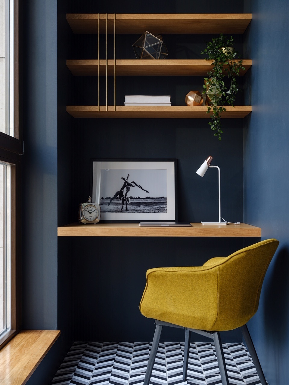 Hệ thống kệ mở, bàn gỗ gắn tường đều được thiết kế bởi Yulia Kamanina và sản xuất theo đơn đặt hàng để đảm bảo “vừa vặn với không gian. Chiếc ghế màu vàng mù tạt kết hợp với sơn tường màu xanh lam đậm trở thành bộ đôi sắc màu ấn tượng.