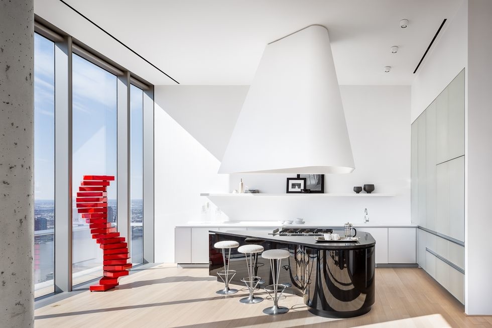 Phòng bếp của căn hộ áp mái trong một tòa nhà chọc trời do Herzog & de Meuron thiết kế với trần nhà cao thoáng, bức tường kính đón ánh sáng và đặc biệt là đảo bếp màu đen với bề mặt kim loại bóng bẩy tạo nên sự tương phản ấn tượng.
