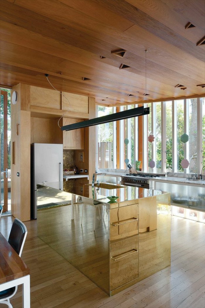 Phòng bếp rộng rãi trong ngôi nhà tại New Zealand sử dụng vật liệu gỗ ốp tường và trần nhà cho vẻ đẹp mộc mạc, gần gũi. Riêng khu vực đảo bếp được hoàn thiện hoàn toàn bằng đồng thau tạo nên điểm nhấn hiện đại trong bếp.