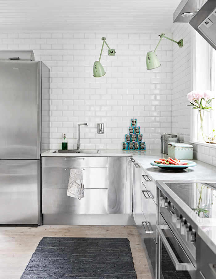 Phòng bếp được xây dựng từ đầu thế kỷ 20 tại Stockholm (Thụy Điển) sau cải tạo đã trở nên rộng rãi hơn nhờ hệ tủ bếp bằng kim loại từ thương hiệu IKEA kết hợp gạch ốp tường dạng thẻ metro cũng có lớp hoàn thiện sáng bóng không kém.