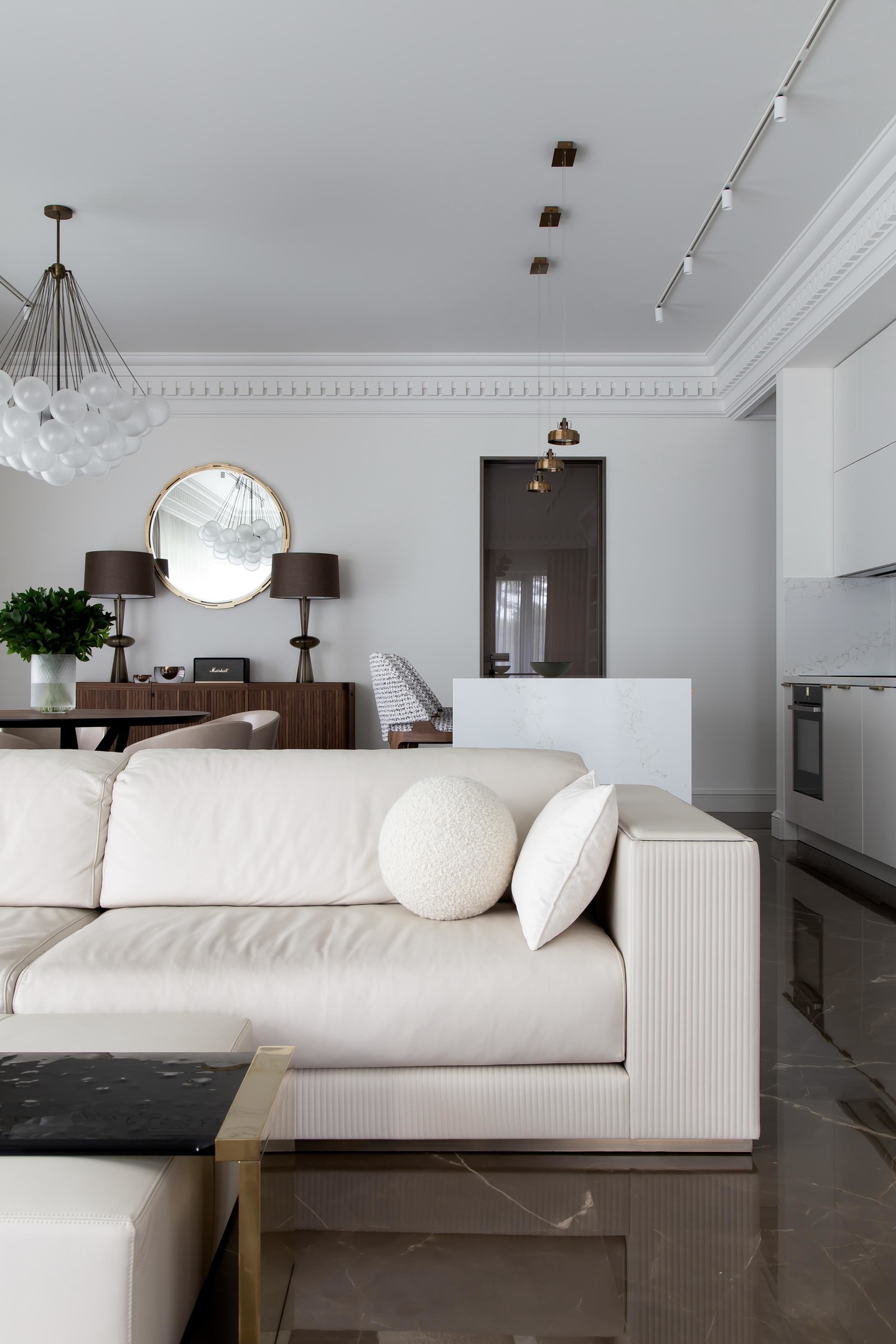 NTK nội thất đã lựa chọn đá cẩm thạch có màu nâu để lát sàn, kết nối phòng khách và cả khu vực nấu nướng - ăn uống phía sau. Nhờ vậy mà chiếc ghế sofa màu trắng kem bỗng trở nên nổi bật dù chỉ là tone màu đơn sắc.
