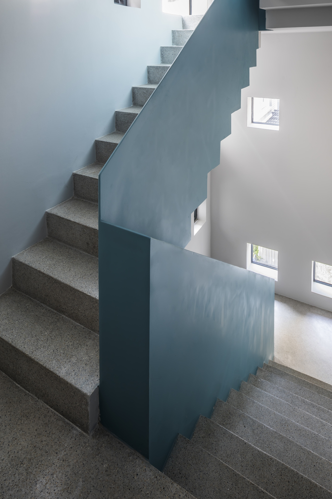 Khu vực cầu thang chuyển tiếp các tầng trong ngôi nhà với tam cấp bằng đá granite, lan can sơn màu xanh ngọc lam vừa nhẹ nhàng nhưng cũng vô cùng nổi bật giữa màu sơn tráng của bức tường.