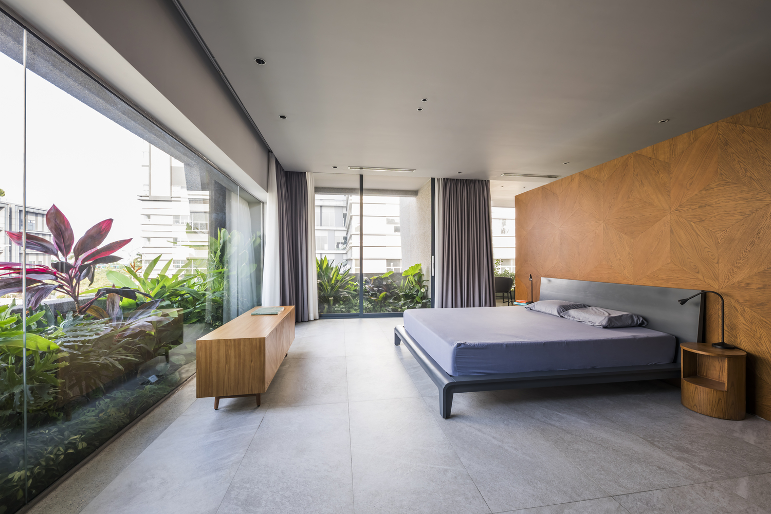 Phòng ngủ thiết kế tối giản với xung quanh là tường kính, sự tiết chế về mặt nội thất cũng giúp cho không gian căn phòng đã rộng rãi càng thêm thoáng đãng.