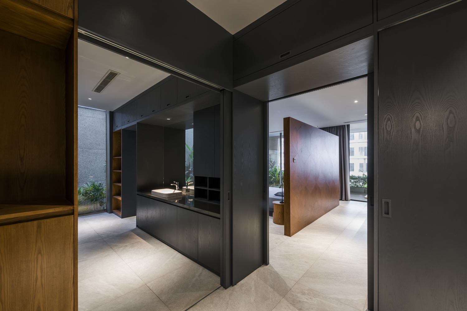 Phòng tắm và nhà vệ sinh được bố trí bên cạnh phòng ngủ, với tone màu đen sang trọng kết hợp hệ thống tủ lưu trữ ẩn tiện nghi.