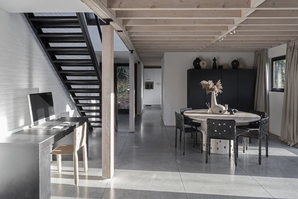 Ngôi nhà của NTK Victoria Yakusha tại Brussels (Bỉ) với thiết kế mở rộng thoáng, nội thất phong cách cổ điển, trần dầm gỗ sáng màu. Bên dưới cầu thang là khu vực dành cho góc làm việc tại gia với chiếc bàn inox tối giản nhưng gọn gàng, thuận tiện.