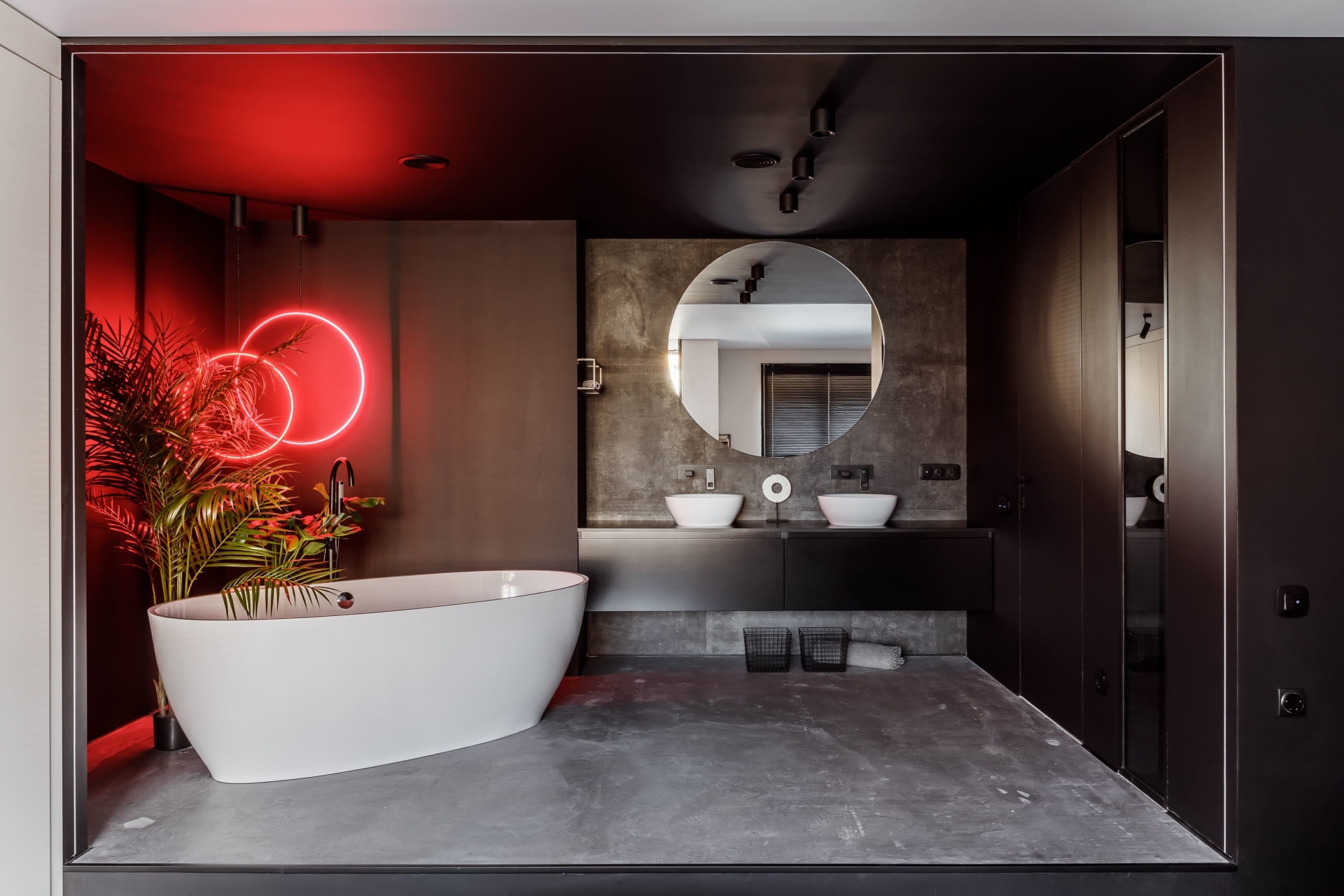 Như đã giới thiệu, phòng tắm của căn hộ thực sự là 'nhân vật chính' bởi vẻ đẹp sang chảnh, không gian rộng rãi (chưa kể diện tích nhà vệ sinh). Sàn lát gạch bê tông, sơn tường và trần màu đen bóng bẩy cùng tấm gương tròn giúp phản chiếu không gian và ánh sáng.