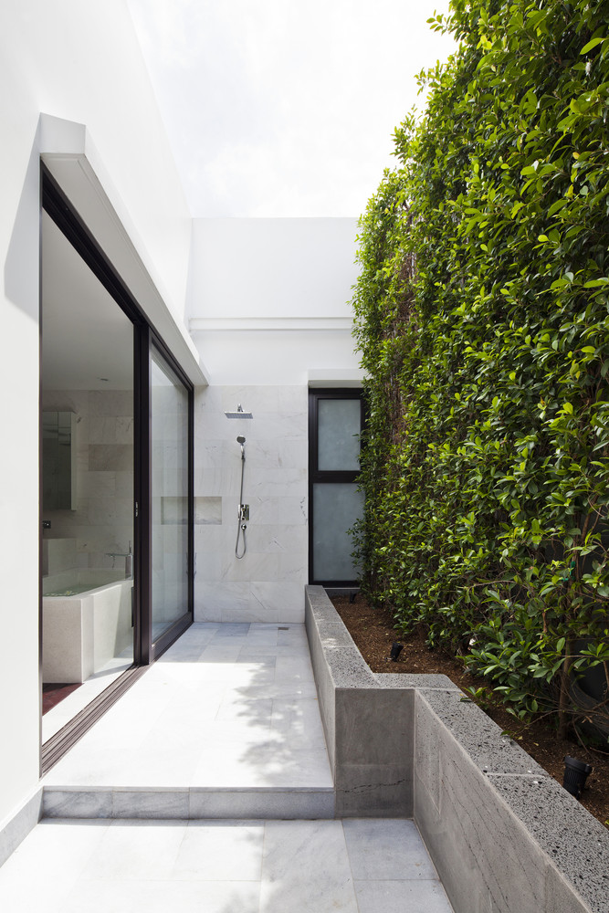 Chủ nhân có thể lựa chọn bồn tắm nằm thư giãn bên trong cánh cửa trượt hoặc tắm vòi sen phía bên ngoài để 'hòa mình' vào bức tường thực vật xanh mướt.