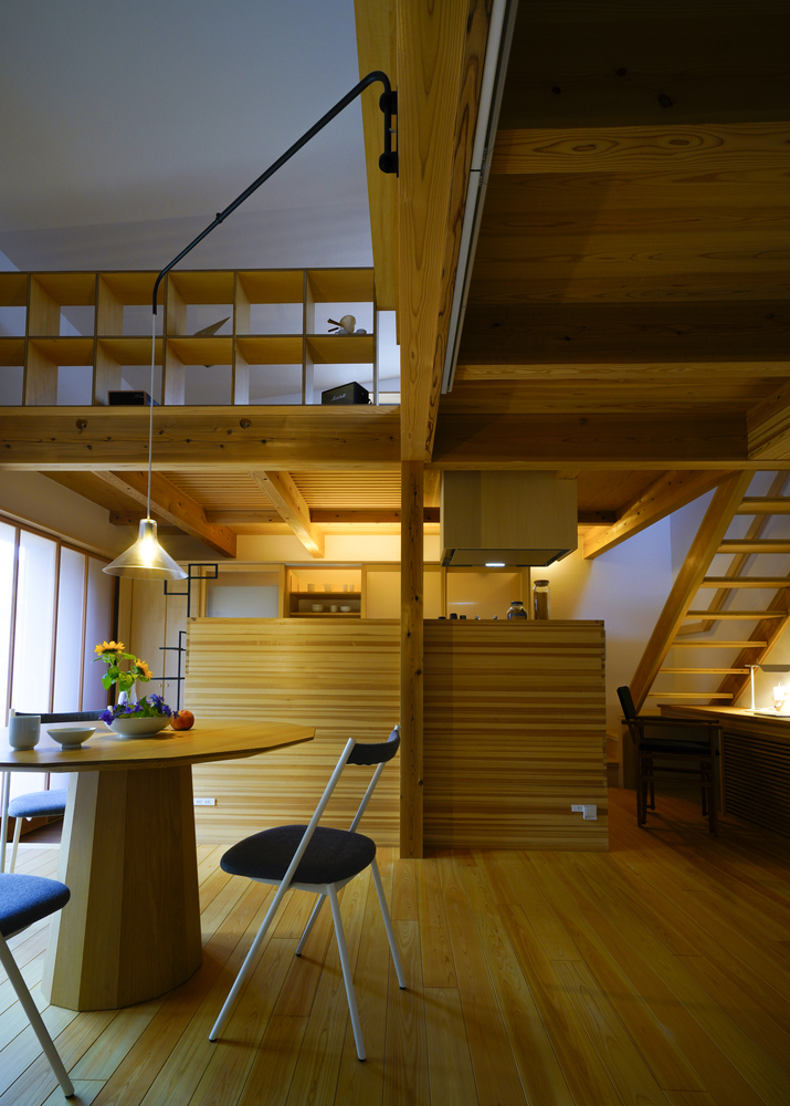 Ánh đèn sử dụng cho khu vực phòng bếp và bàn ăn có ánh sáng vàng, kết hợp màu nâu gỗ cho cảm giác không gian sinh hoạt thêm ấm cúng. Cầu thang dẫn lối đưa chúng ta lên tầng trên cũng thiết kế với phong cách tối giản.