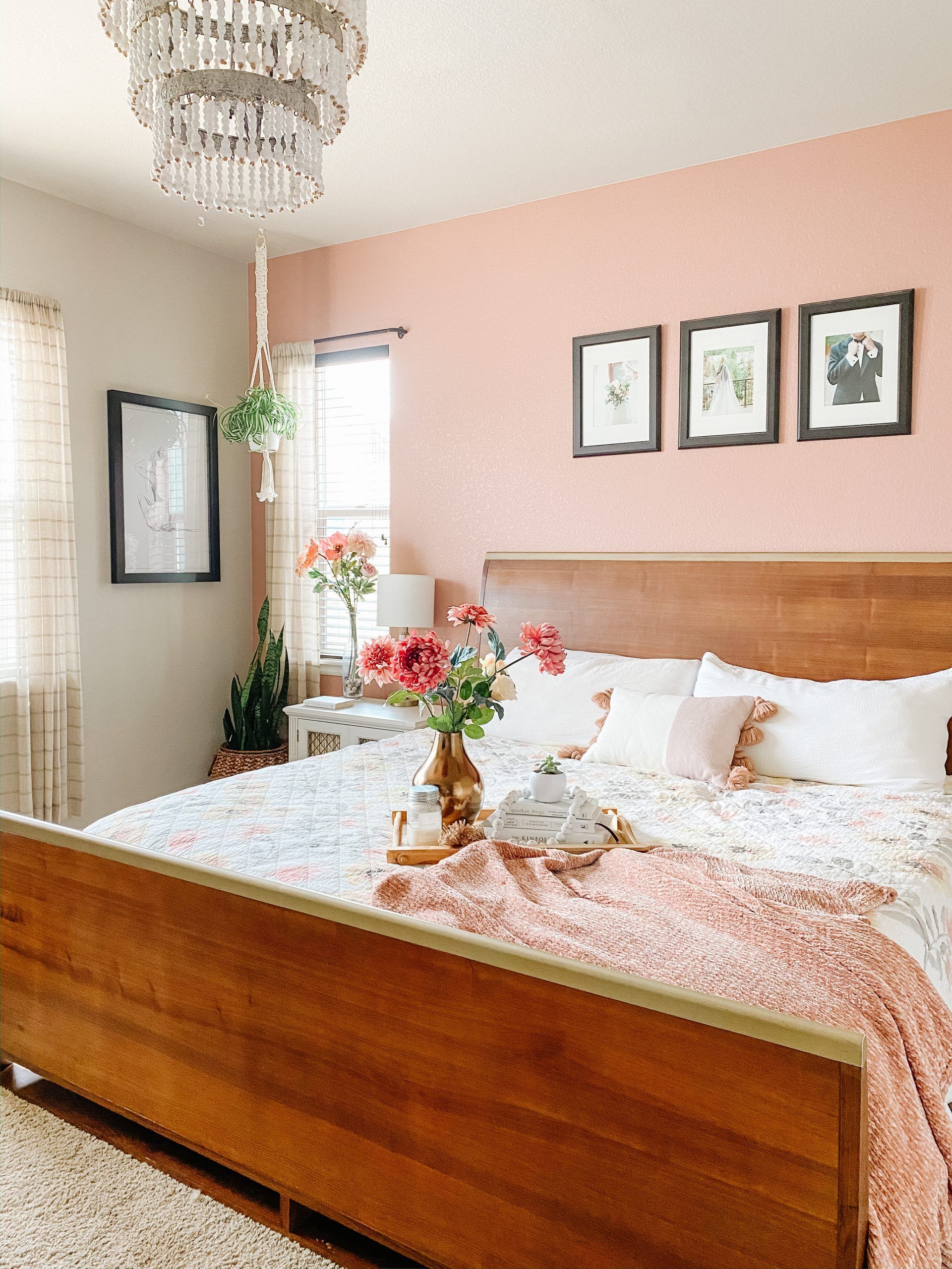 Phòng ngủ siêu ngọt ngào với sơn tường hồng và khung giường gỗ tone màu nâu trầm ấm. Chủ nhân của nó đã khéo léo kết hợp với các lọ hoa tươi, chậu cây lưỡi hổ, cỏ lan chi,... để bầu không khí sinh động và thanh lọc không khí tốt hơn.