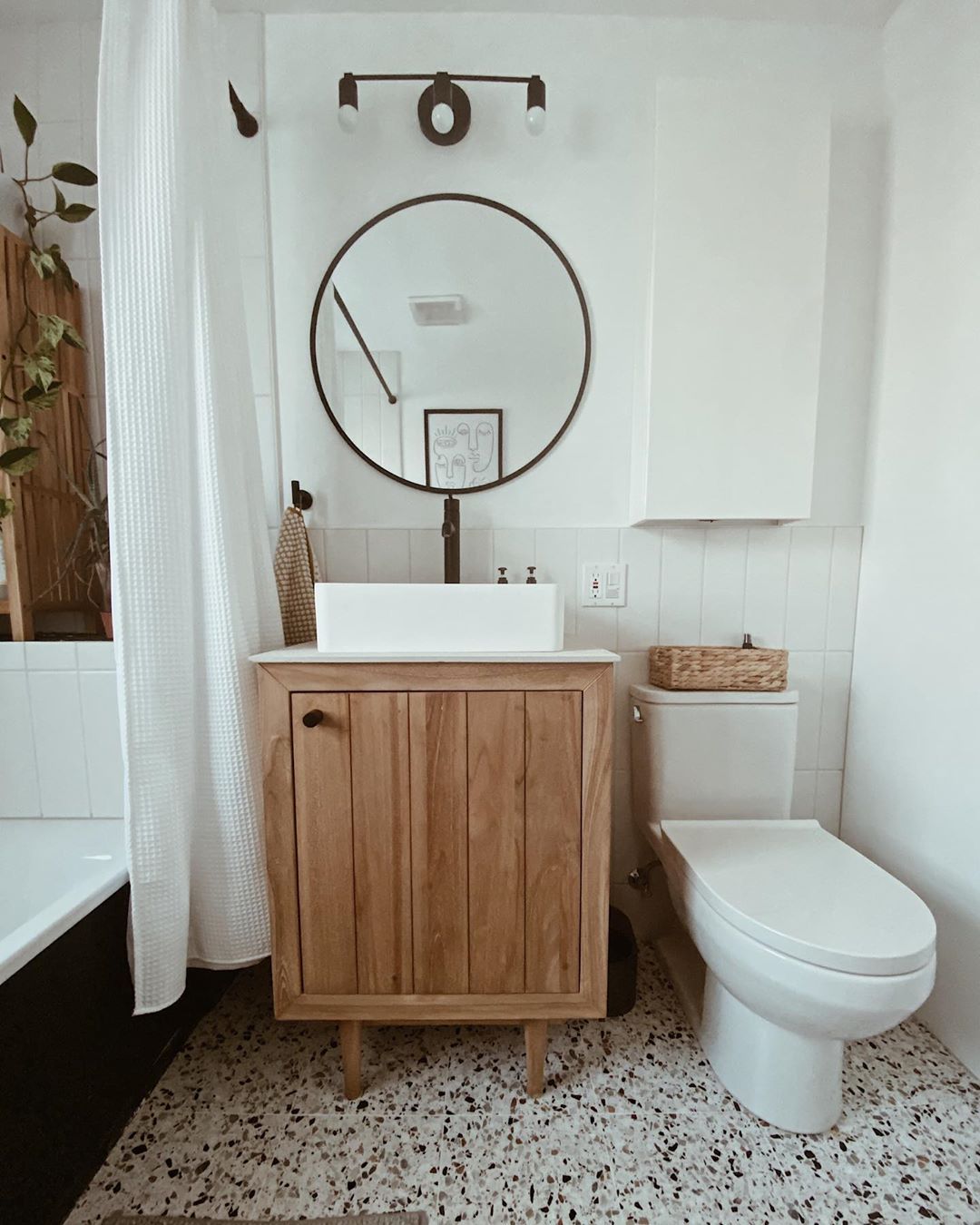 Nếu không nhìn kỹ, bạn sẽ bỏ qua chiếc tủ lưu trữ màu trắng, bề mặt nhẵn mịn phía trên toilet vì nó như ẩn mình vào nền tường đúng không nào? Thêm chiếc hộp đan thủ công bằng sợi lục bình ngay trên bồn cầu thì càng thêm xinh xắn. 