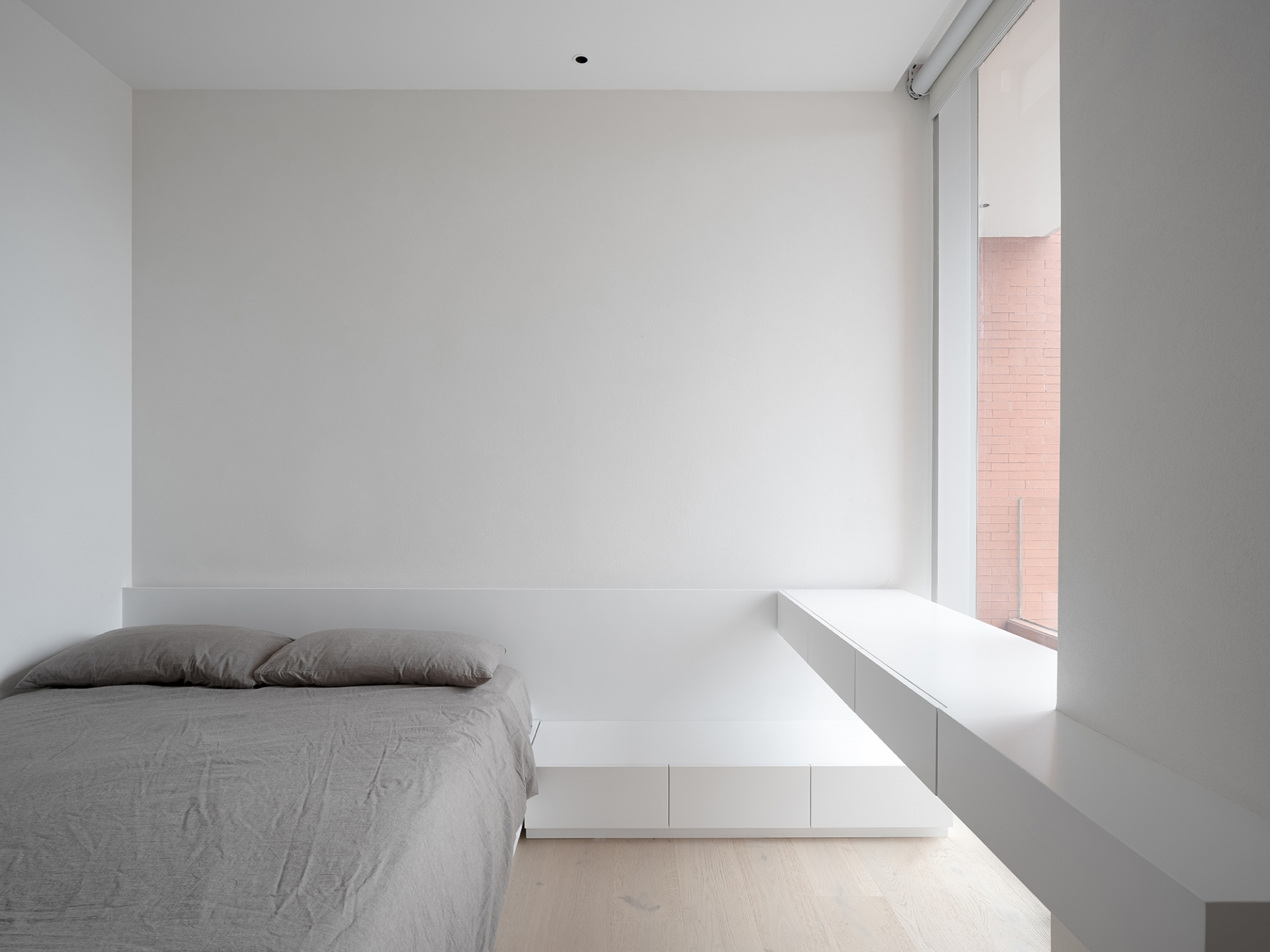 Phòng ngủ chính và phòng ngủ cho khách đều được thiết kế tối giản với gam màu trắng - xám, tiết chế nội thất tối đa để tạo sự rộng rãi. 