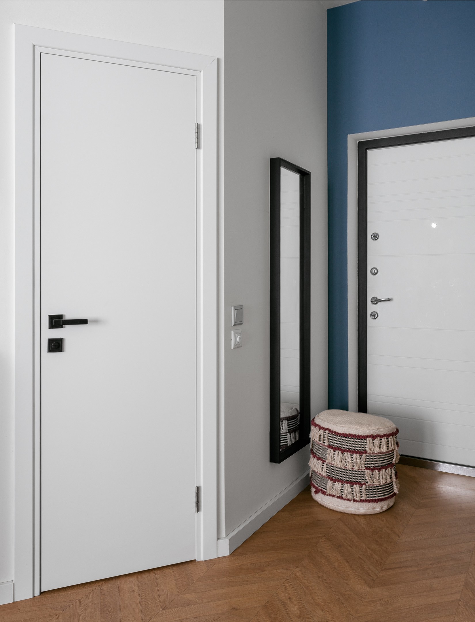 Lối vào sử dụng sơn tường màu xanh lam đậm tại cánh cửa ra vào, thêm một chiếc ghế đôn êm ái cùng tấm gương khổ dọc để chủ nhân 'làm điệu' trước khi ra khỏi nhà. 