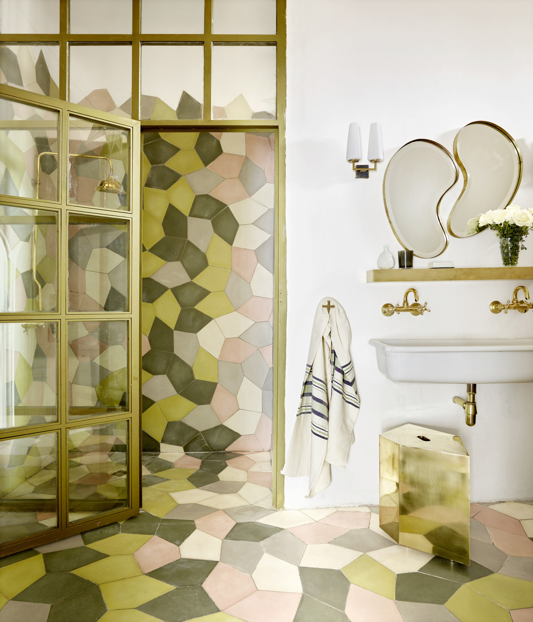 Sự ghép nối những viên gạch ốp lát tươi tắn, đa sắc màu tạo nên một bức tranh sinh động cho phòng tắm. Thêm vào những chi tiết vòi hoa sen, viền khung gương, vòi rửa kim loại mạ vàng đồng càng thêm sang trọng.