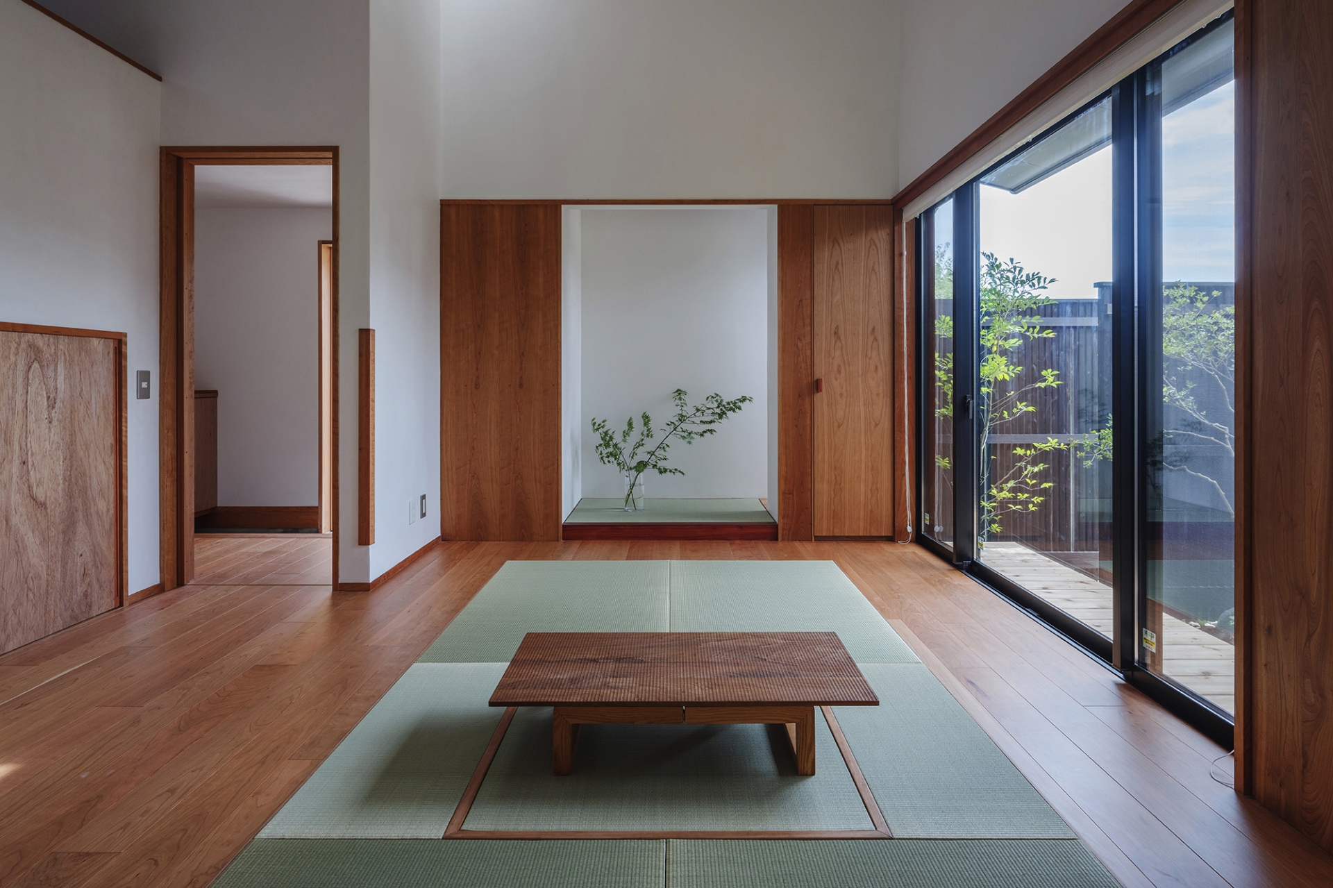 Toàn bộ ngôi nhà sử dụng gam màu trắng thanh lịch kết hợp vẻ ấm áp của gỗ cùng phong cách thiết kế tối giản. Chiếu tatami màu xanh bạc hà trải ở trung tâm phòng khách, bố trí bàn trà thấp sàn đặc trưng của nội thất xứ Phù Tang.
