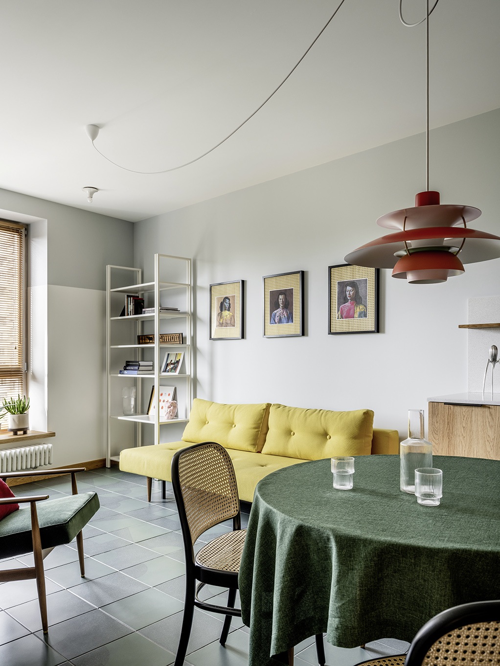 Để phân vùng phòng khách và phòng ăn trong bố cục thiết kế mở, NTK nội thất đã lựa chọn vải bọc màu vàng tươi cho ghế sofa và khăn trải bàn ăn màu xanh lá cây đậm, giúp phân vùng không gian hiệu quả bằng thị giác.