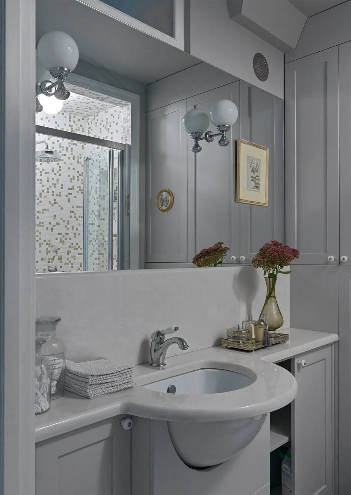 Phòng tắm cũng là khu vực thay đổi rõ nét sau cải tạo, cụ thể, bồn tắm nằm được thay bằng buồng tắm vòi sen để tiết kiệm diện tích. Tấm gương lớn ốp tường giúp 'nhân đôi' không gian và ánh sáng.