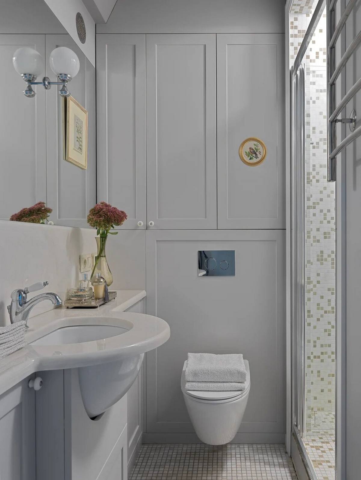 Nếu khu vực sinh hoạt chung thiết kế theo phong cách đồng quê cổ điển thì phòng tắm và nhà vệ sinh hiện đại hơn với toilet gắn tường giải phóng diện tích mặt sàn. Hệ tủ lưu trữ ốp tường cũng giúp cho căn phòng gọn gàng, tươi sáng hơn.