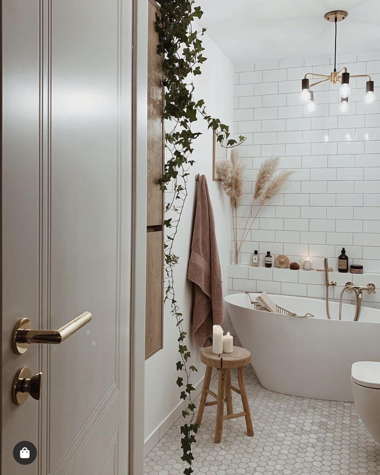 Phòng tắm thiết kế theo phong cách Boho phóng khoáng với gạch penny lục giác lát sàn, ghế đẩu bằng gỗ giản dị và cỏ pampas cắm trong bình xinh xắn.